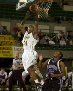 Chad in a white basketball jersey (#24) jumping in the air to get the ball into the basket.